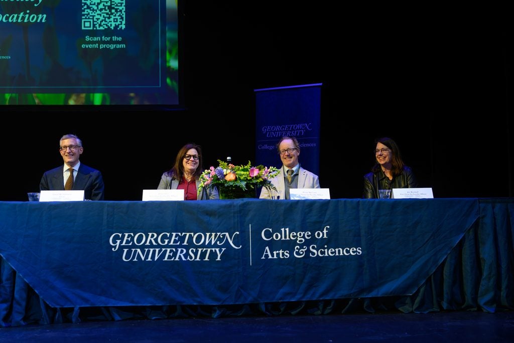 Four Georgetown University administrators sitting in front of a long table.